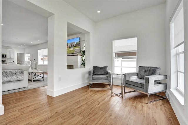 sitting room with baseboards, recessed lighting, and light wood-style floors
