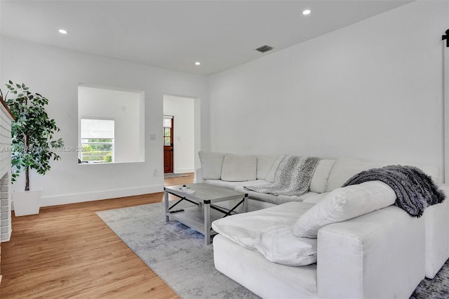 living room featuring baseboards, visible vents, recessed lighting, and wood finished floors