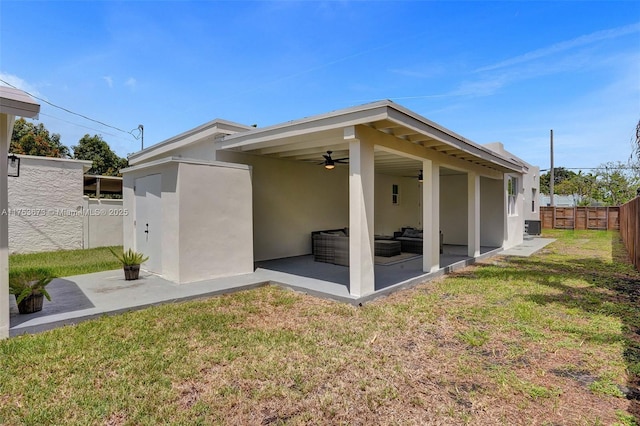 back of property featuring stucco siding, a fenced backyard, a ceiling fan, a yard, and a patio area