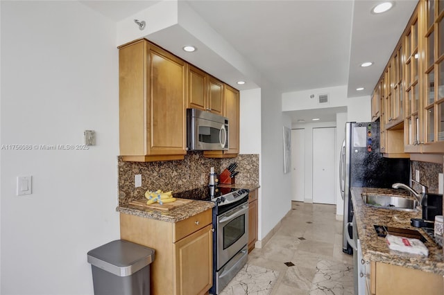 kitchen with visible vents, glass insert cabinets, backsplash, stainless steel appliances, and a sink