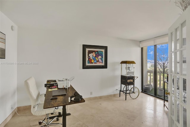 office space with expansive windows and baseboards