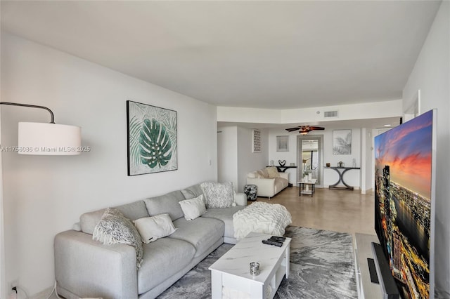 living room with ceiling fan, visible vents, and wood finished floors