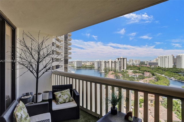 balcony featuring a water view and a city view