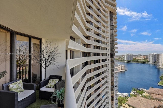 balcony featuring a water view and a city view