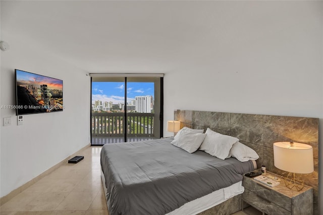 bedroom with access to exterior, floor to ceiling windows, baseboards, and light tile patterned flooring