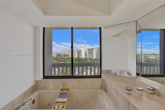 full bath featuring a view of city, a healthy amount of sunlight, and a whirlpool tub