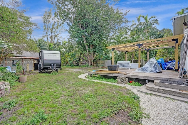 view of yard featuring fence, a wooden deck, and a pergola