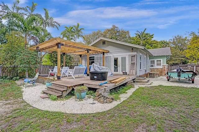 rear view of property featuring french doors, a fenced backyard, a wooden deck, and a pergola