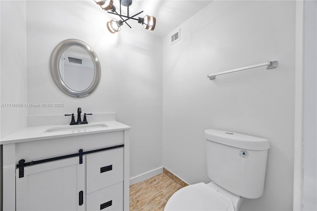 bathroom featuring toilet, a notable chandelier, visible vents, vanity, and baseboards