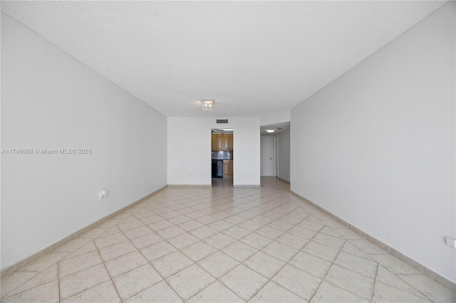 empty room with visible vents, baseboards, and a textured ceiling