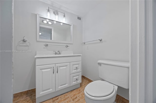 bathroom with toilet, visible vents, and vanity