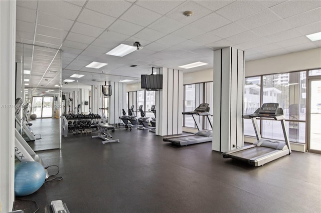 workout area with a paneled ceiling and a wealth of natural light