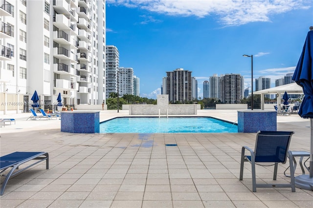 pool with a view of city and a patio area