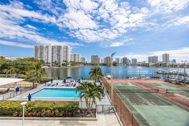 pool with a water view, fence, a city view, and a patio