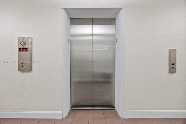 interior details featuring elevator and baseboards