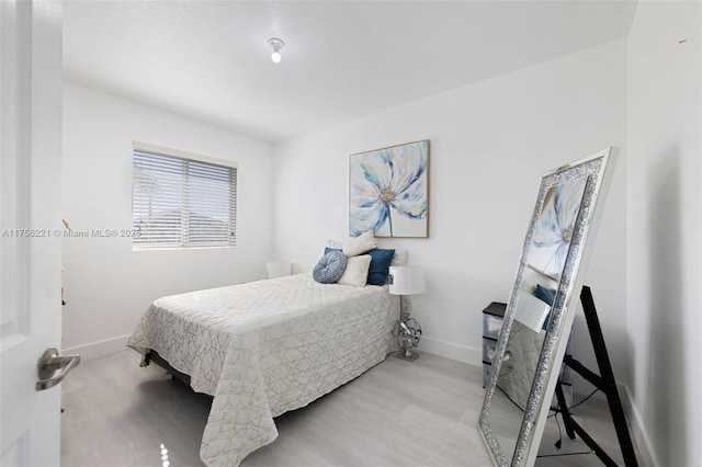 bedroom featuring baseboards and wood finished floors