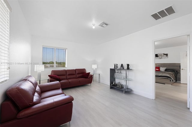 living area with light wood finished floors, baseboards, and visible vents