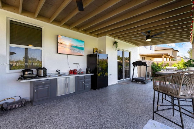 view of patio / terrace featuring ceiling fan, an outdoor kitchen, and a sink