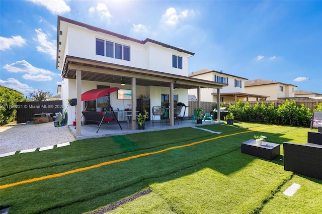 rear view of property featuring a patio, a yard, a fenced backyard, and stucco siding