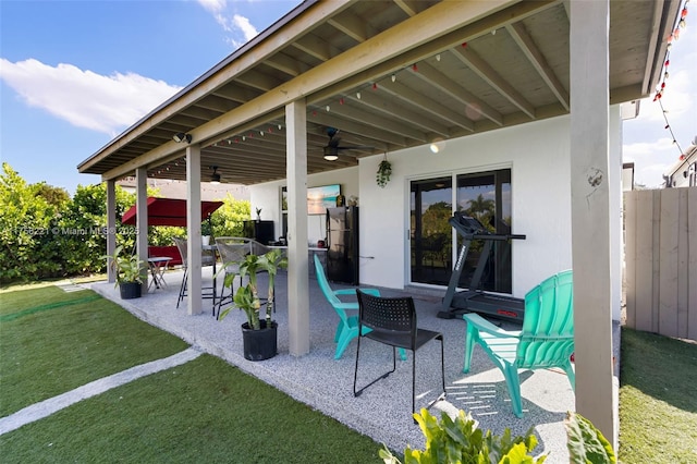 view of patio / terrace with ceiling fan and fence