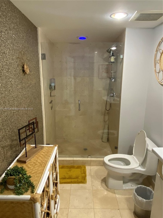 bathroom featuring tile patterned flooring, toilet, vanity, and a stall shower