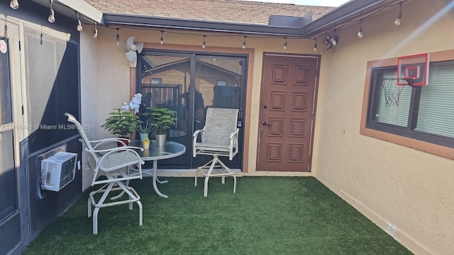 doorway to property featuring stucco siding and a shingled roof