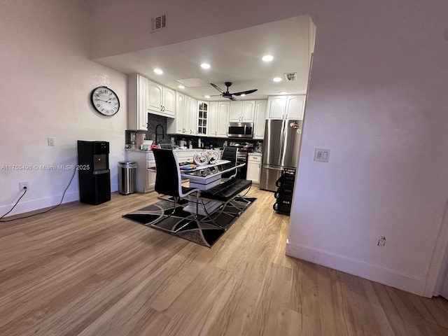 dining area with a ceiling fan, light wood-style floors, visible vents, and baseboards