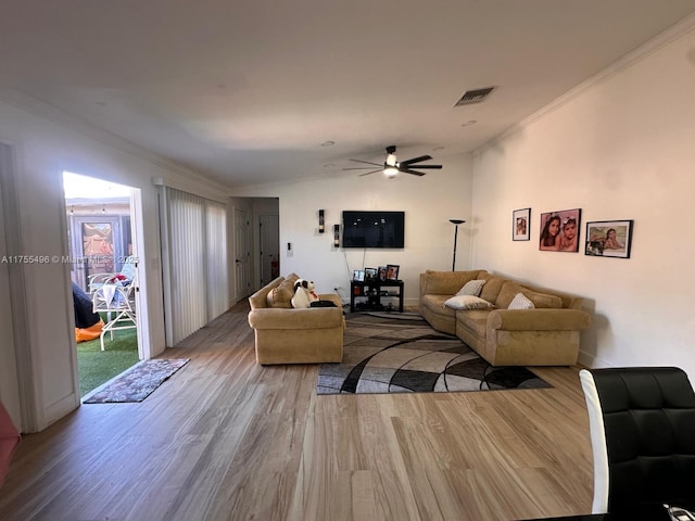 living area featuring lofted ceiling, wood finished floors, and ornamental molding