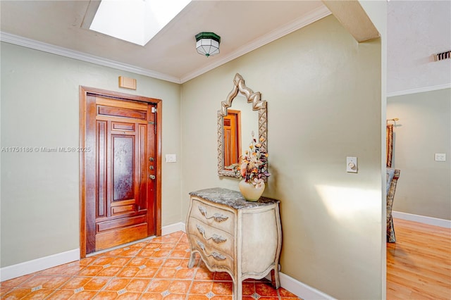 entryway with a skylight, baseboards, and ornamental molding