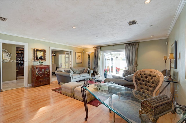 living area with recessed lighting, a textured ceiling, ornamental molding, and light wood finished floors