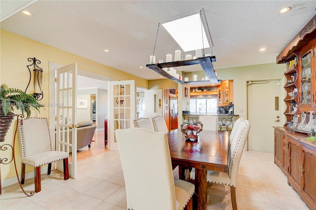 dining room with light tile patterned floors, french doors, a skylight, and recessed lighting