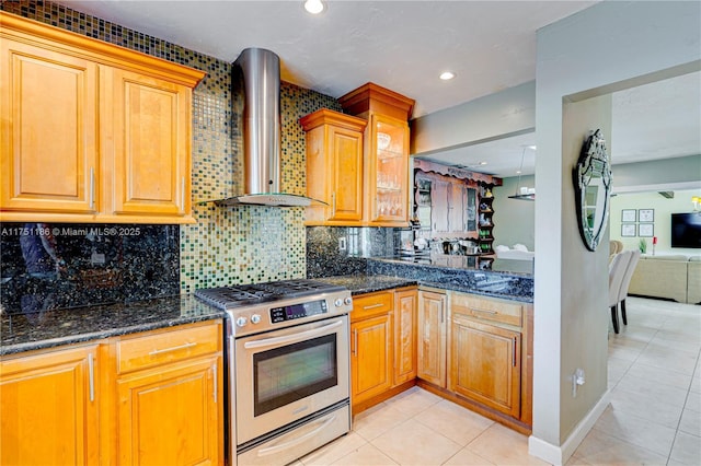 kitchen with dark stone countertops, backsplash, recessed lighting, wall chimney exhaust hood, and stainless steel gas range