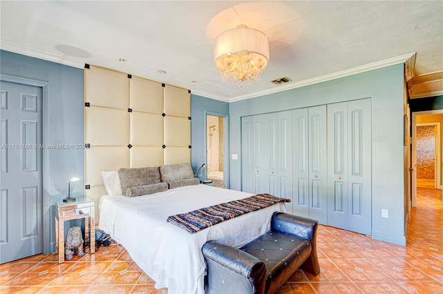 bedroom with visible vents, ornamental molding, a closet, an inviting chandelier, and light tile patterned floors