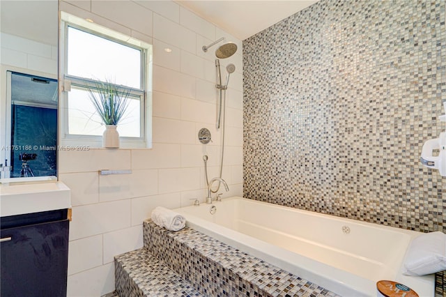 full bath featuring tile walls, vanity, and tiled shower / bath