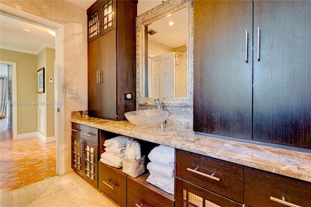 bathroom with tile patterned floors, baseboards, ornamental molding, and vanity