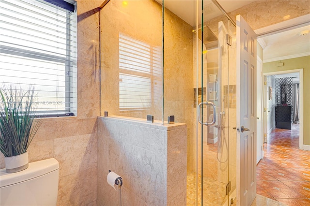 bathroom featuring tile patterned flooring, a shower stall, toilet, and crown molding