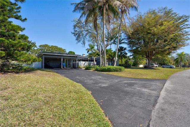 view of front of house with aphalt driveway, an attached carport, and a front yard