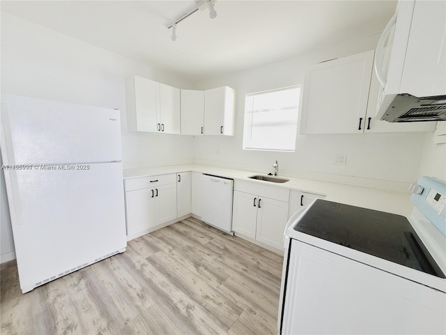 kitchen with light wood finished floors, light countertops, white cabinets, a sink, and white appliances