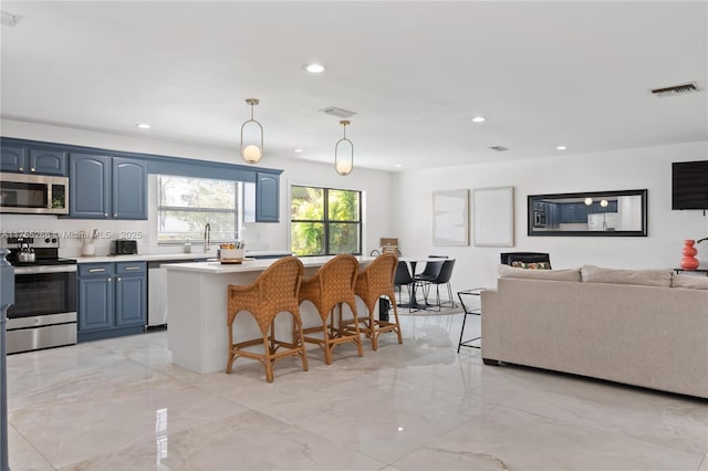 kitchen with a breakfast bar, light countertops, visible vents, appliances with stainless steel finishes, and blue cabinets