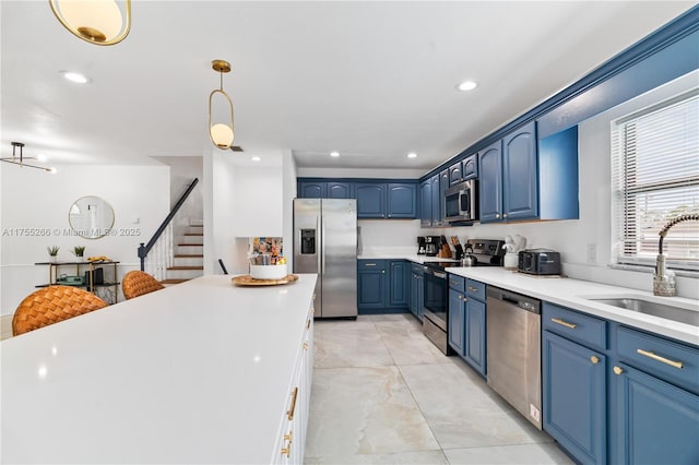 kitchen featuring stainless steel appliances, light countertops, blue cabinetry, a sink, and recessed lighting