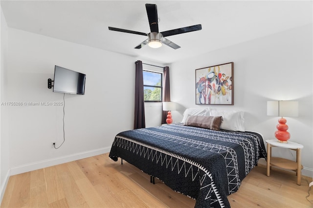 bedroom featuring ceiling fan, baseboards, and wood finished floors