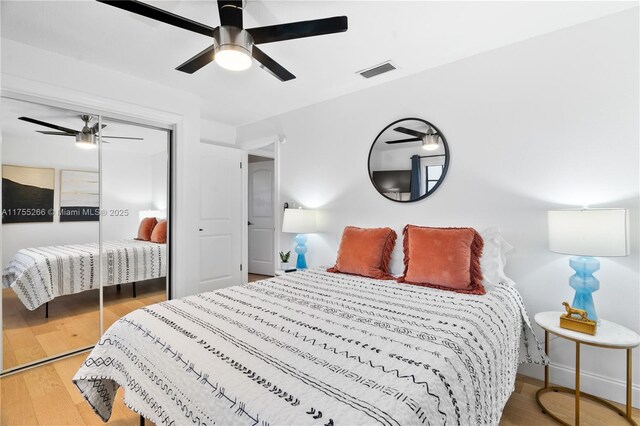 bedroom featuring a closet, wood finished floors, visible vents, and a ceiling fan