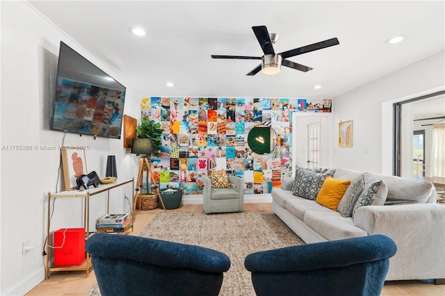 living room featuring a ceiling fan, recessed lighting, an accent wall, and baseboards