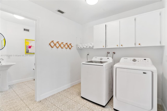 laundry area featuring cabinet space, independent washer and dryer, visible vents, and baseboards