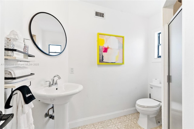 bathroom with toilet, a stall shower, visible vents, and baseboards