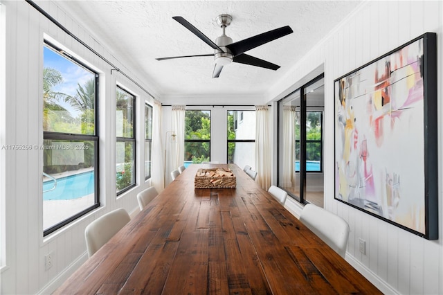 unfurnished sunroom with ceiling fan