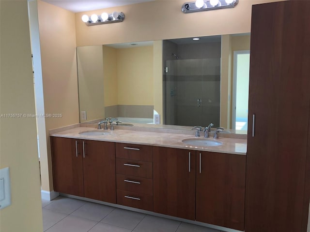 full bath with double vanity, a stall shower, tile patterned flooring, and a sink