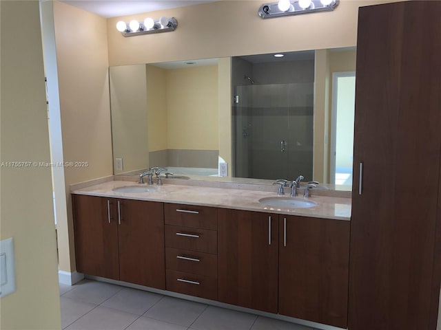 full bathroom featuring a stall shower, double vanity, a sink, and tile patterned floors