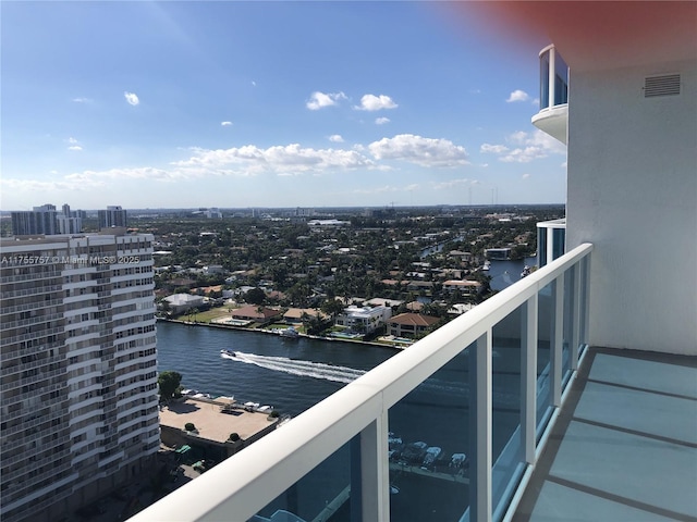 balcony featuring a view of city, a water view, and visible vents