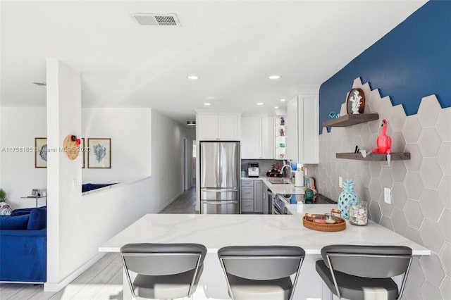 kitchen featuring electric range, a sink, visible vents, freestanding refrigerator, and open shelves